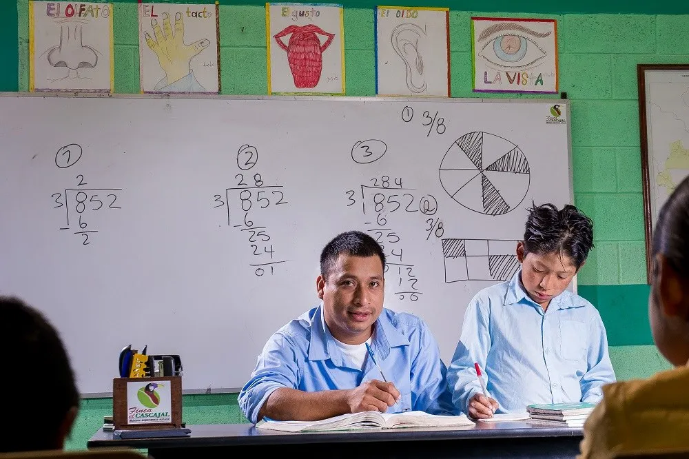 Maestro y alumnos en el aula de la escuela de Finca El Cascajal
